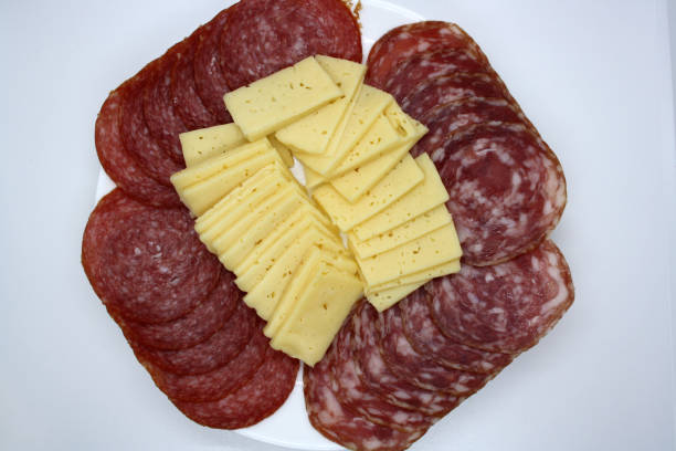 istock Salami slices and cheese on a white plate. 1303342614
