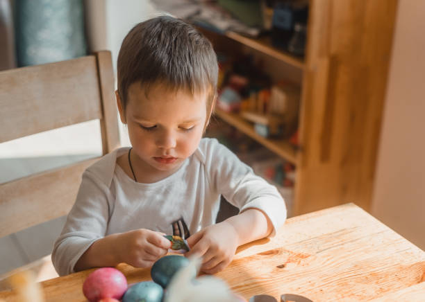 istock A little boy painting and decorating Easter eggs 1303344189