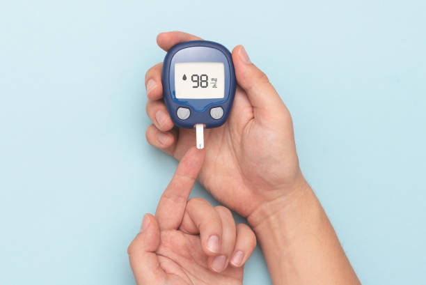 человек, использующий глюкометр, проверяя уровень сахара в крови - blood sugar test стоковые фото и изображения