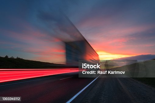 istock Motion blur. The truck is driving at high speed on the highway. Red Sky. 1303345112
