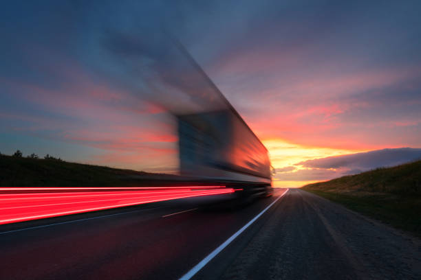 borrão de movimento. o caminhão está dirigindo em alta velocidade na rodovia. céu vermelho. - car highway speed traffic - fotografias e filmes do acervo