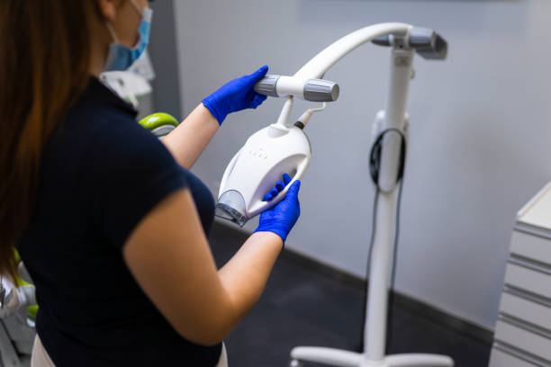 istock Dentist with teeth whitening machine 1303346168