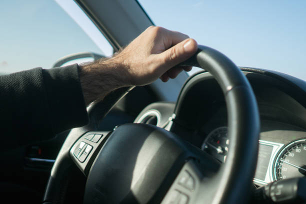 istock Hands of car driver on steering wheel, road trip. 1303346480