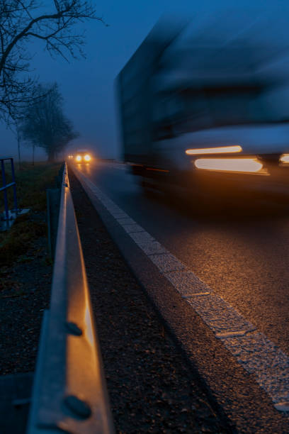 istock Lighted cars at dusk on  main road 1303347169