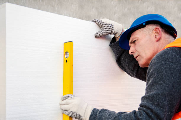 istock Construction worker placing styrofoam sheet insulation to the wall at construction site 1303347863