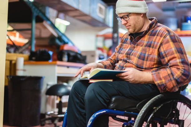istock Millennial Male College Student with Disability in Wheelchair Working and Studying at Work Photo Series 1303347925