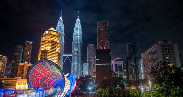 low angle view Kuala Lumpur Cityscape at night with saloma bridge connection in between old town and new city buildings across highway