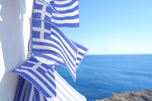 Greek flags attached on a white wall in Folegandros Greece