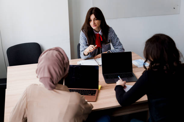 istock Foreign school private study with a school girl. Teacher explain grammar of native language using laptop. Prepearing to exam with tutor. 1303350617