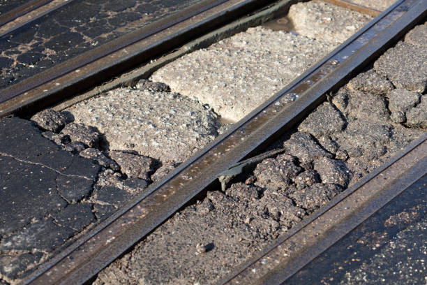 на улице между трассами из-за зимних погодных условий создана яма - pot hole street car hole стоковые фото и изображения