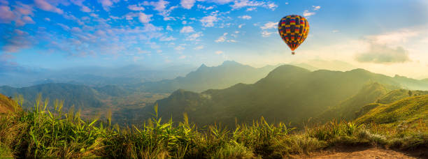 Photo of Panorama of mountain with hot air balloons on morning at Thailand.
