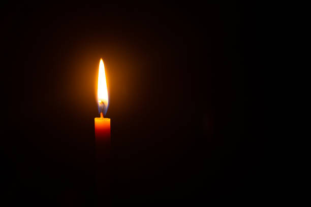 istock Close up single candle light and flame on black backgrou 1303351028