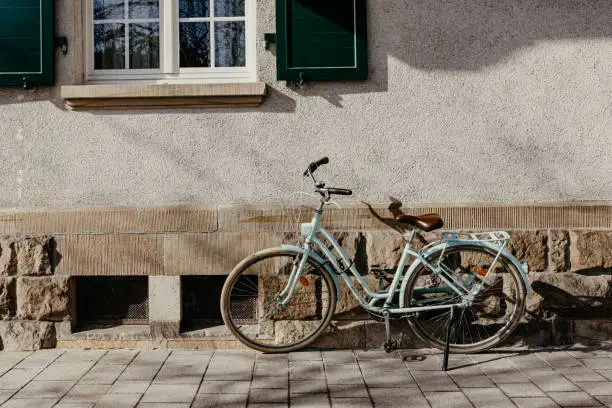 a green bicycle in front of a house wall in the city