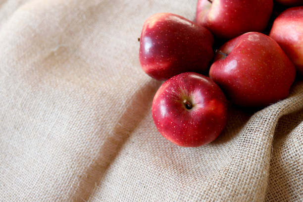 Istanbul, Turkey-February 21, 2021: Few Red Ripe Apples on Burlap Fabric. Full Frame, Still life, Studio shot, Flat lay. Shot with Canon EOS R5, Canon RF 35mm Lens.