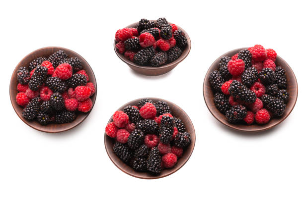 blueberries and raspberries in small baskets made of birch bark on a wooden background. harvest of wild berries, vitamins and health benefits