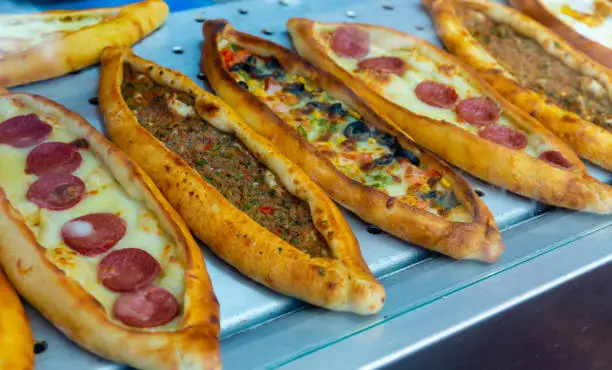 Photo of Traditional Turkish pide with various fillings on bakery showcase