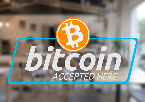 Bitcoin Crypto Currency Accepted Here sticker on the store window.\nBlur restaurant background. bitcoin electronic money for business concept.