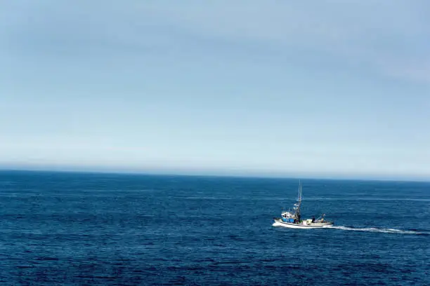 nice view of a fishing boat sailing in the immense blue ocean