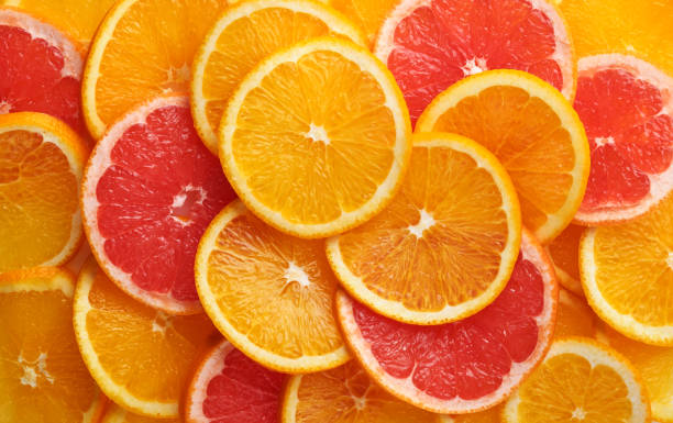 istock Abstract background of orange and grapefruit citrus slices on white. 1303360912