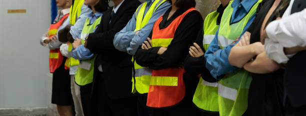창고 나 창고에 함께 서있는 공장 노동자의 큰 그룹 - 통일 뉴스 사진 이미지