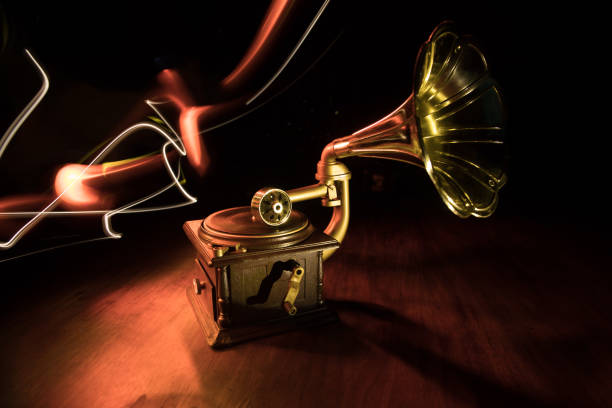 Music concept. Old gramophone on a dark background. Retro gramophone with disc on wooden table with toned backlight. Selective focus