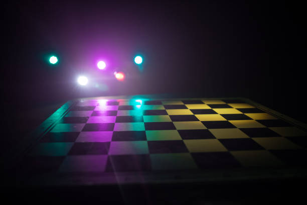 istock empty chess board with smoke float up on dark background with colorful backlight. 1303362277