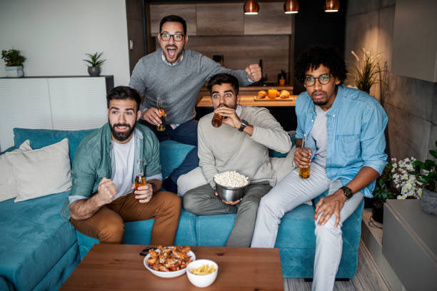 istock Friends watching sport on tv 1303363216