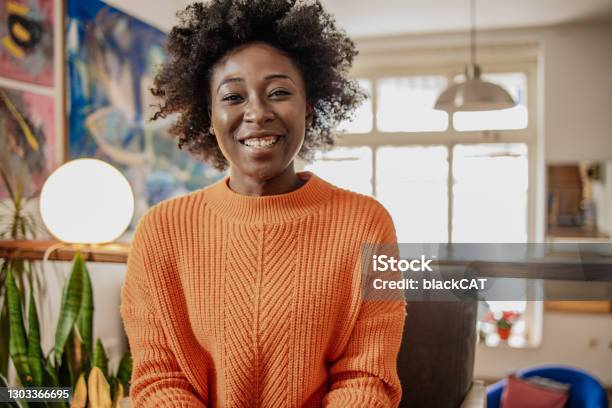 Portrait Of Smiling African American Young Woman Indoors Talking To Camera Video Calling Recording Vlog Stock Photo - Download Image Now