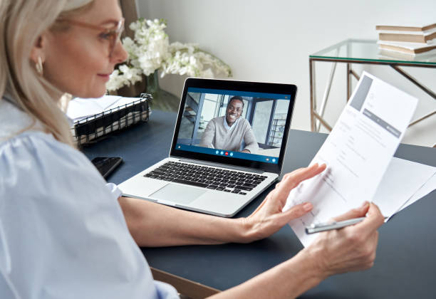 Female hr reading cv during online virtual job interview by video call. Employer checking african male recruit resume talking by distance remote recruitment chat meeting video conference on laptop. Female hr reading cv during online virtual job interview by video call. Employer checking african male recruit resume talking by distance remote recruitment chat meeting video conference on laptop. recruiter photos stock pictures, royalty-free photos & images