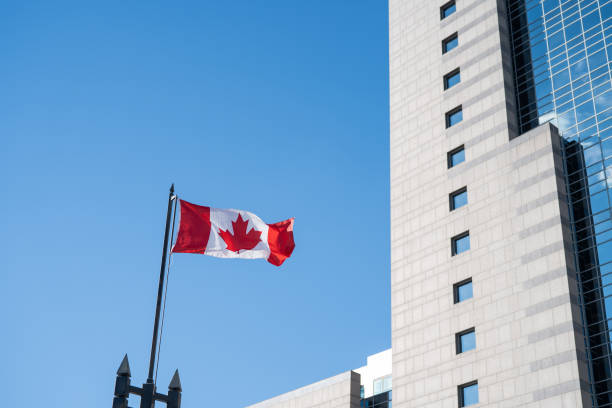 istock The flag of Canada under the blue sky 1303369131