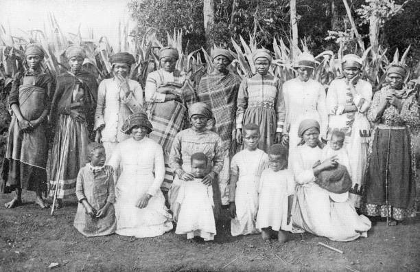 amazulu mulheres e meninas vestindo roupas europeias em uma vila kraal no reino de zululand, áfrica do sul - século xix - women century 19th victorian style - fotografias e filmes do acervo