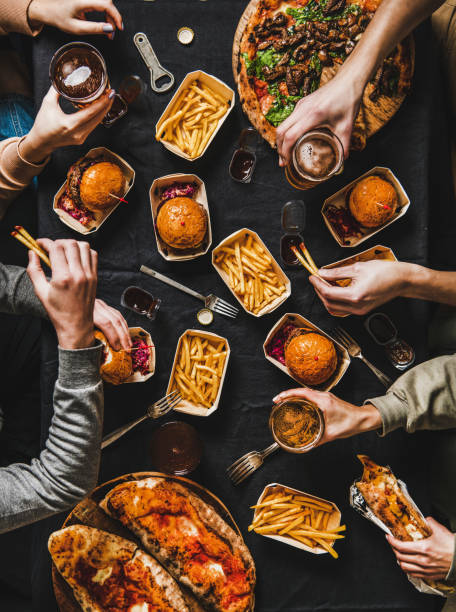 flat-lay di amici che hanno una festa a casa in quarantena con fast food - cibo da asporto foto e immagini stock