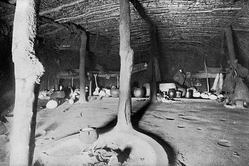 The interior of a traditional Zulu iQukwane (hut) at a Zulu kraal (village) in the Kingdom of Zululand, South Africa. Vintage photo etching circa 19th century. It was absorbed into the British Colony of Natal in 1897, and then the Union of South Africa in 1910.