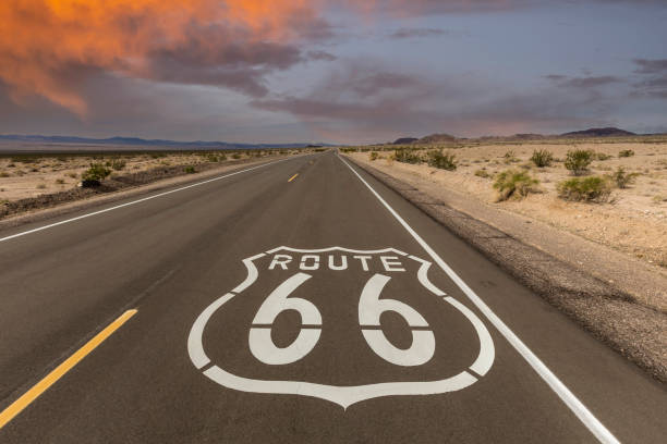 Route 66 Mojave Desert Pavement Sign with Sunset Sky Historic Route 66 pavement sign with sunset sky near Amboy in the California Mojave desert. number 66 stock pictures, royalty-free photos & images