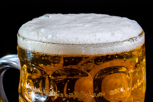 Mug of beer on dark background close-up