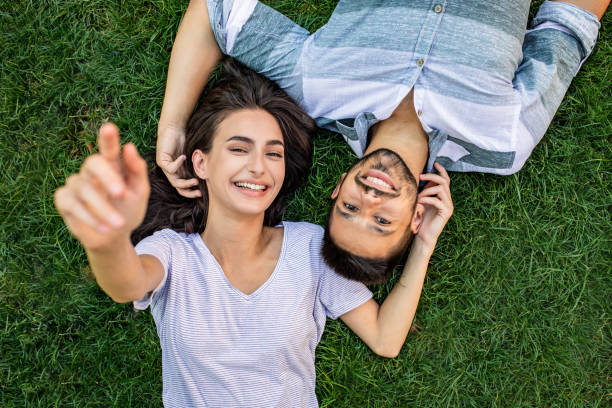 istock Young couple lying on the grass in park and relaxing 1303375157