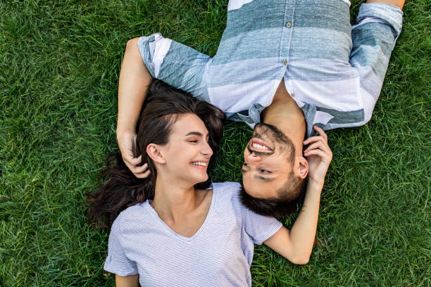 istock Young couple lying on the grass in park and relaxing 1303375169