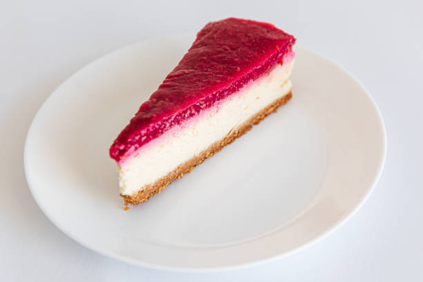 istock Close up of Cheesecake slice on a white plate. Raspberry cheesecake. Copy space. selective focus 1303375419