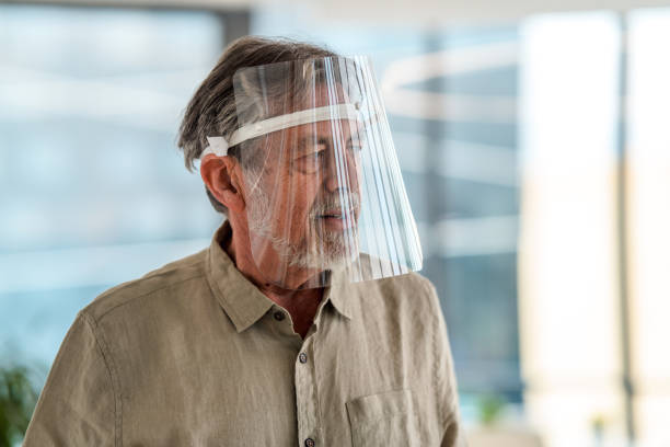 istock Caucasian Mature Man Wearing Wearable Computer in an Office 1303377293