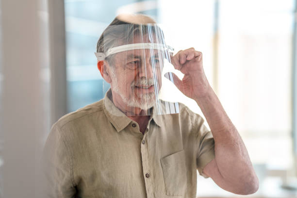 istock Caucasian Mature Man Wearing Wearable Computer in an Office 1303377294