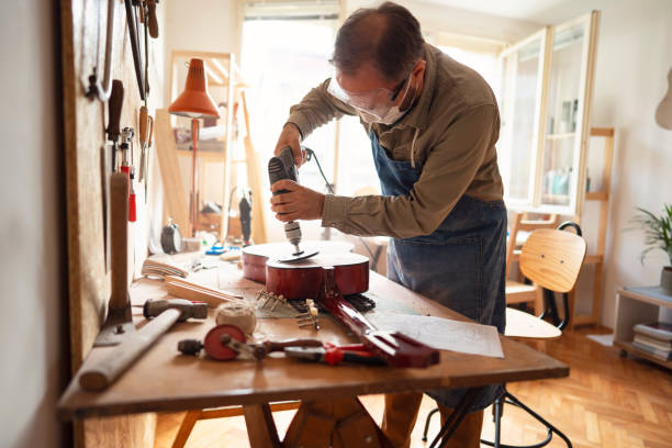 istock Craftsman is sanding guitar in his workshop 1303378437