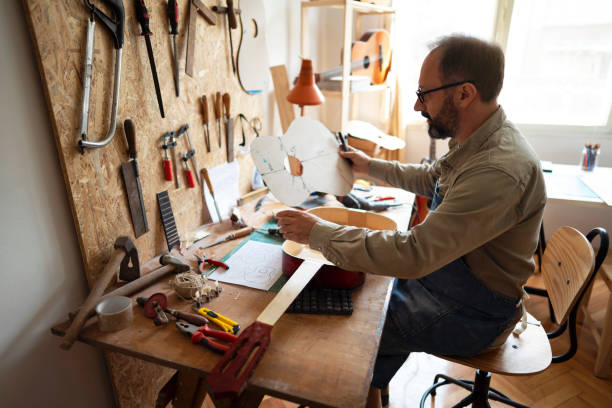 istock Craftsman is looking at the guitar scheme in his workshop 1303378468