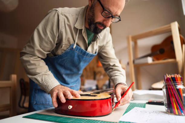 istock Craftsman drawing a template for new guitar 1303378473