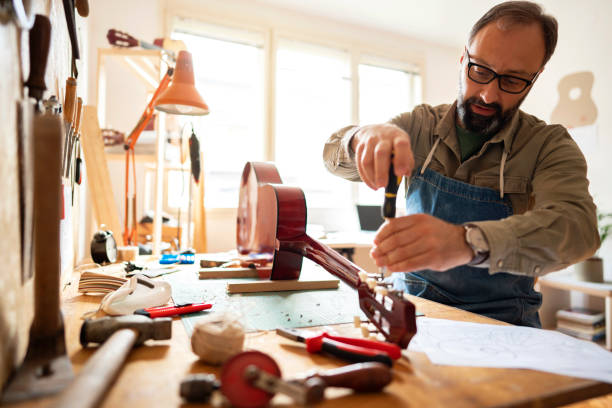istock Craftsman repairing the guitar 1303378504