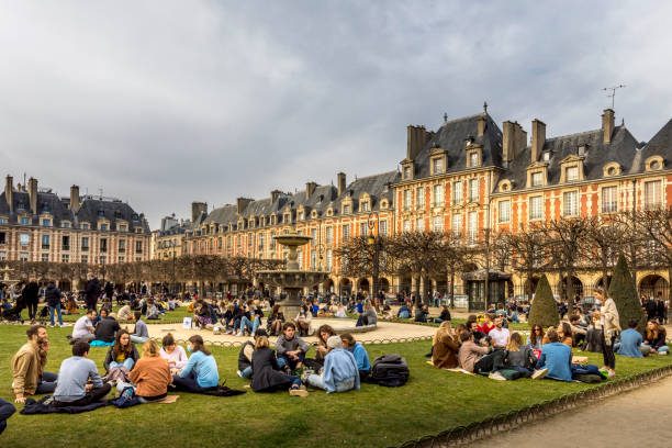 persone che si rilassano sui prati verdi della famosa place des vosges - la più antica piazza pianificata di parigi, durante la pandemia di covid-19. - jewish quarter foto e immagini stock