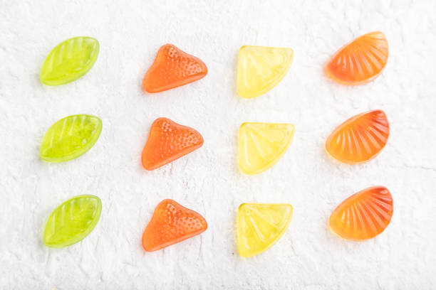Various fruit jelly candies on gray concrete background. top view, flat lay, close up.