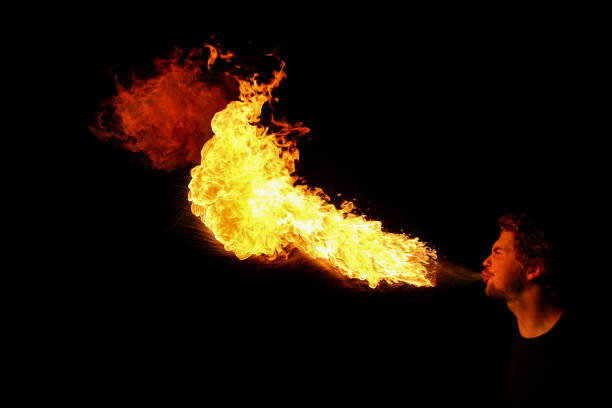 un devorador de fuego que sopla grandes llamas - fire eater fire performance circus performer fotografías e imágenes de stock