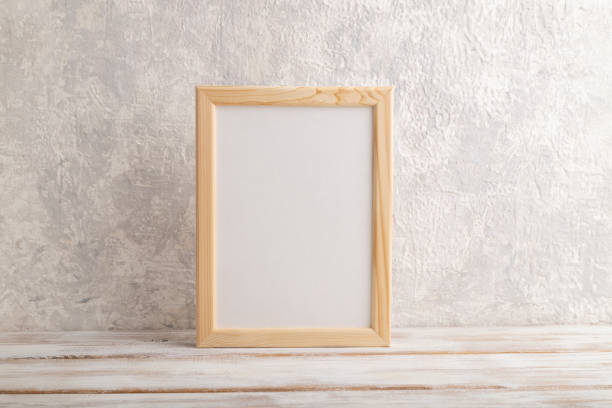 istock White wooden frame mockup on gray concrete background. Blank, vertical orientation, still life, copy space. 1303380273