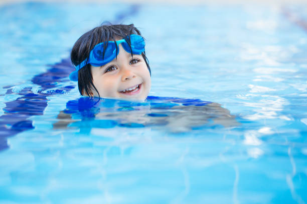 istock Happy boy enjoying summer time in swimming pool 1303383511