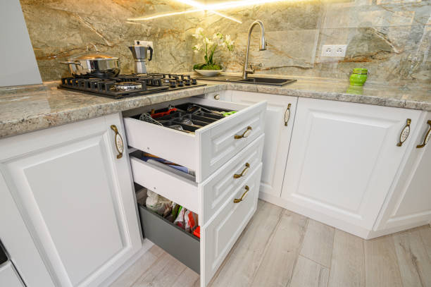 istock Drawers pulled out at modern classic white kitchen furniture 1303384643